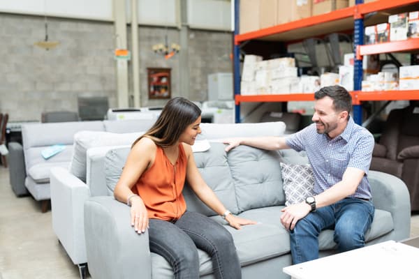 A smiling man and woman on a loveseat